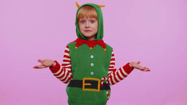 Confused girl in Christmas costume feeling embarrassed about ambiguous question having doubt no idea - Photo, Image