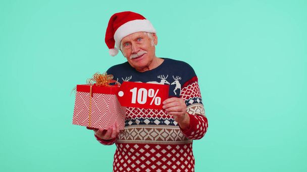 Grandfather in Christmas sweater showing gift box and 10 Percent discount inscriptions banner text - Фото, изображение
