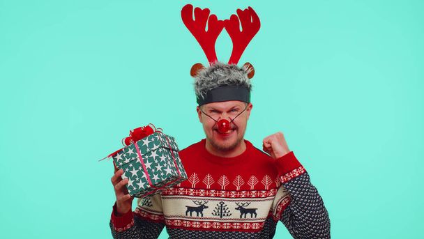 Hombre en jersey de Navidad llora porque no recibir regalo, después de recibir regalo comienza a regocijarse - Foto, Imagen