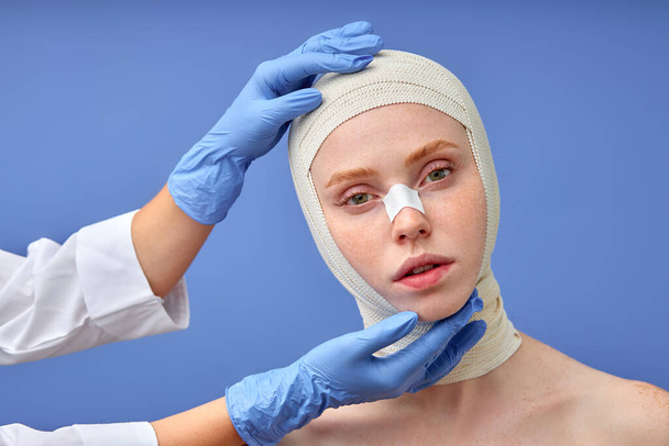 Beautiful woman after cosmetology surgery. Doctor in gloves touch patients face. - Foto, Imagen