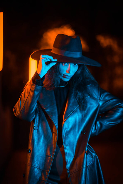 Girl with hat in a pose at night with blue led lighting. winter evening fashion - 写真・画像