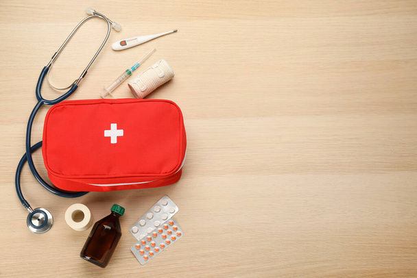 First aid kit on light wooden table, flat lay. Space for text - Fotoğraf, Görsel