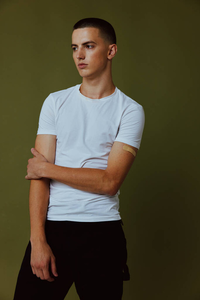 Mann im weißen T-Shirt Impfpass posiert im Studio - Foto, Bild
