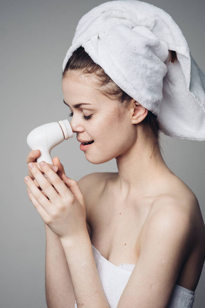 woman with towel on head facial massager skin care hygiene - 写真・画像
