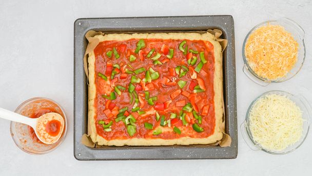 Домашній рецепт вегетаріанської піци. Тісто для піци з томатним соусом і свіжими подрібненими овочами крупним планом на сковороді, плоский лежак
 - Фото, зображення