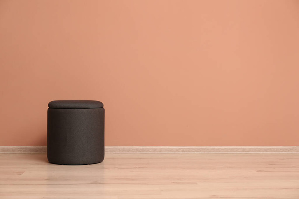 Comfortable pouf near pale pink wall indoors, space for text - Foto, Imagem