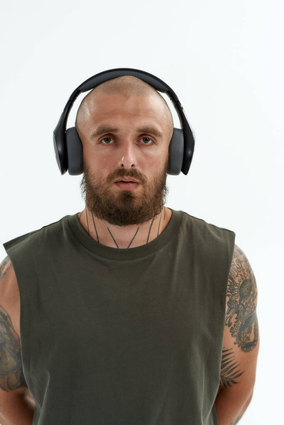 Serious caucasian man listening music in earphones - 写真・画像