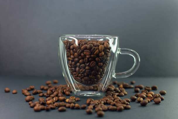 Transparent coffee cup full of coffee beans. - Фото, изображение