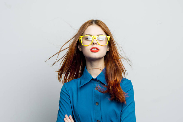 mulher de camisa azul óculos amarelos posando moda - Foto, Imagem