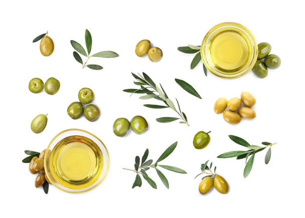 Bowls of oil, ripe olives and leaves on white background, top view - Foto, immagini