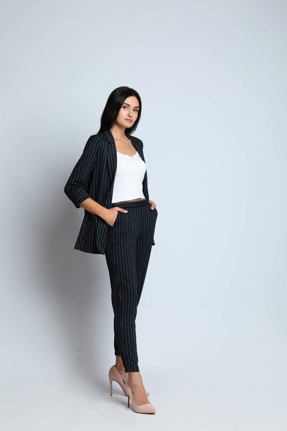 Full length portrait of beautiful woman in formal suit on light background. Business attire - Foto, Imagem