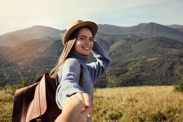 Young woman with her boyfriend in mountains on sunny day - Fotoğraf, Görsel