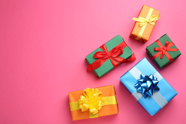 Many colorful gift boxes on pink background, flat lay. Space for text - 写真・画像