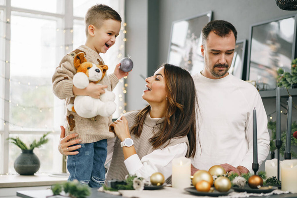 A portrait of happy family in the kitchen decorated for Christmas - Fotoğraf, Görsel