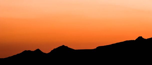 Fondo de una hermosa puesta de sol de colores con la silueta de las montañas - Foto, imagen