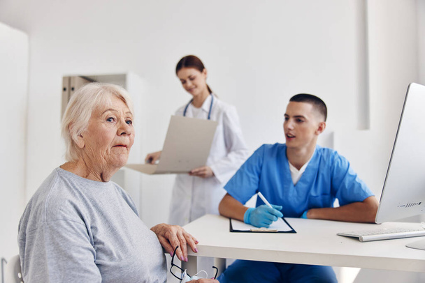 επικοινωνία ηλικιωμένων ασθενών με γιατρό στο ιατρικό γραφείο - Φωτογραφία, εικόνα