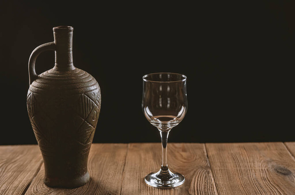 jug with wine and a glass on a wooden table - Foto, Imagen