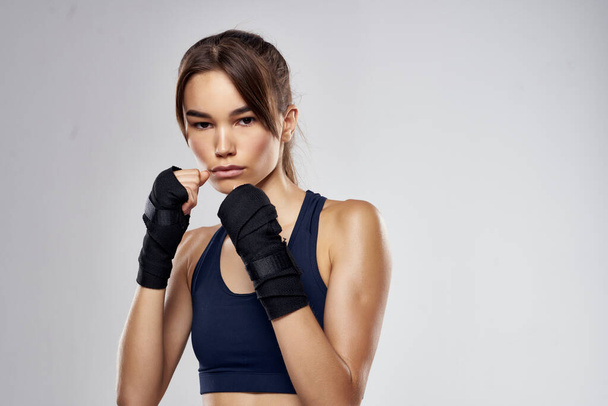 jolie femme en bandages de boxe entraînement fitness combattant fond isolé - Photo, image
