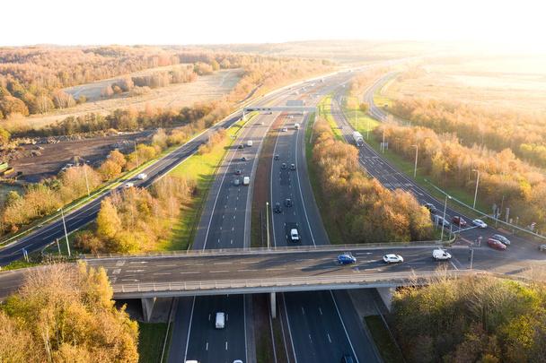 Letecký pohled na britskou dálnici a nadjezd přes malebnou krajinu při západu slunce - Fotografie, Obrázek