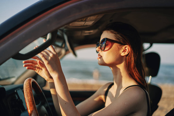 веселая женщина в солнцезащитных очках за рулем автомобиля путешествия - Фото, изображение