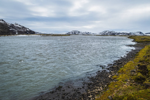 Resmedilmeye değer sonbahar nehri ve Landmannalaugar dağları çok uzaklarda karlarla kaplı. İzlanda dağlık bölgeleri. - Fotoğraf, Görsel