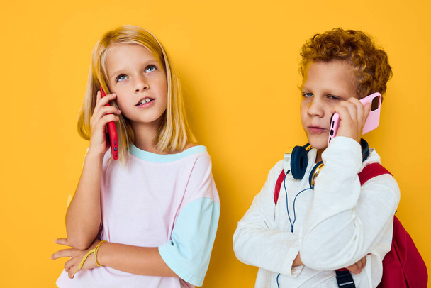 teenage boy and girl use gadgets with headphones - Foto, afbeelding