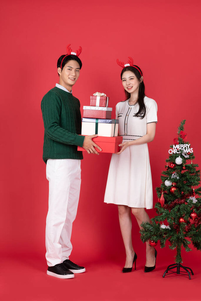 Asian Korean couple in winter fashion with rudolph hairband, Christmas shopping event concept - Fotó, kép