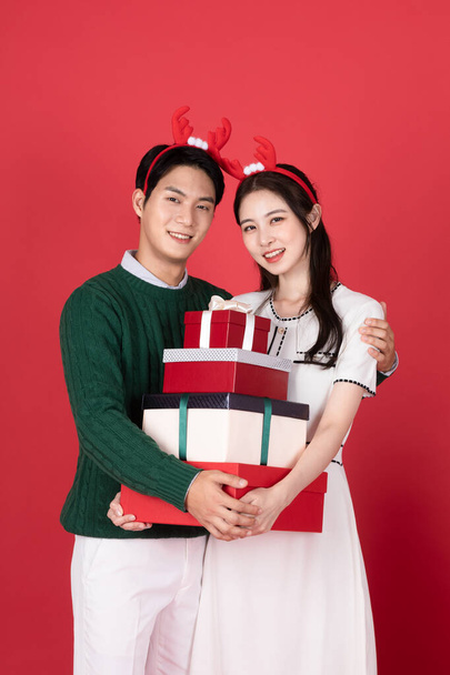 Asian Korean couple in winter fashion with rudolph hairband, Christmas shopping event concept - Фото, изображение