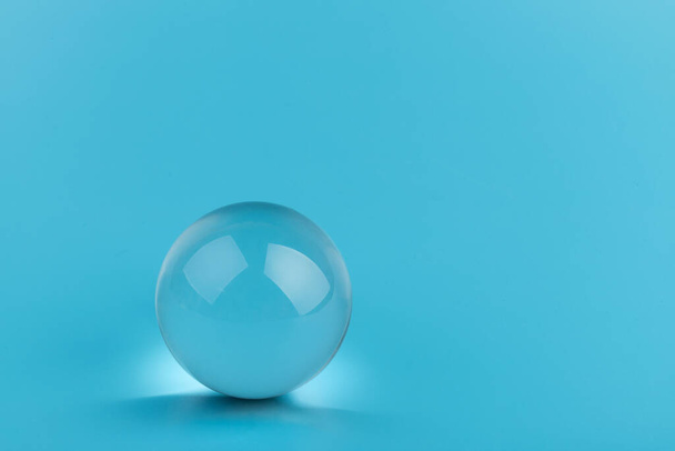 Cristal, boule transparente, sphère sur fond bleu. Verre. - Photo, image