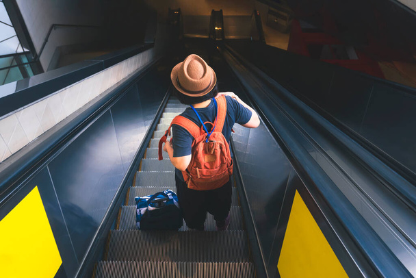 Metro istasyonunda yürüyen merdivenden inen kadın yolcuların yüksek açısı ve dikiz açısı. - Fotoğraf, Görsel