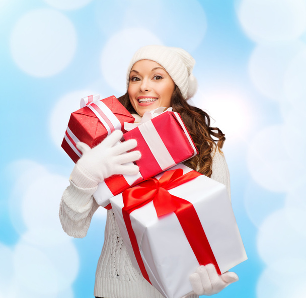 smiling young woman in santa helper hat with gifts - Фото, изображение