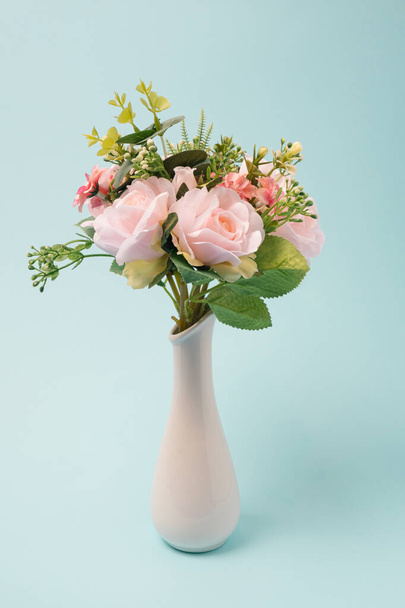 Vase with colorful flowers on a light blue background. Spring, romantic decoration - Photo, image