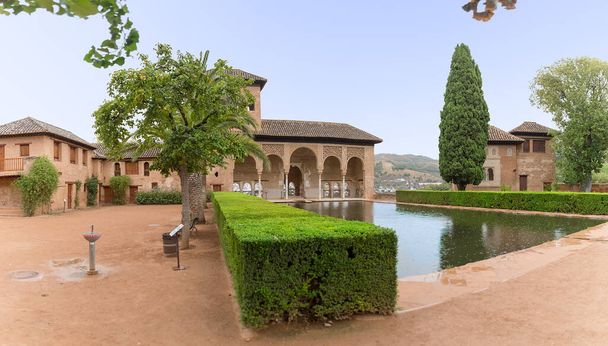 Alhambra Granada Hiszpania - 09 14 2021: Widok na pałac Partal lub Palacio del Partal, pałac wokół ogrodów i jeziora wodnego w kompleksie twierdzy Alhambra w Granadzie, Hiszpania - Zdjęcie, obraz