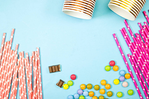 Mutlu yıllar, Çikolata Şeker ve saman ve tek kullanımlık bardaklar mavi arka planda - Fotoğraf, Görsel