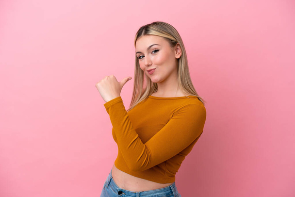 Young caucasian woman isolated on pink background proud and self-satisfied - Foto, Imagen