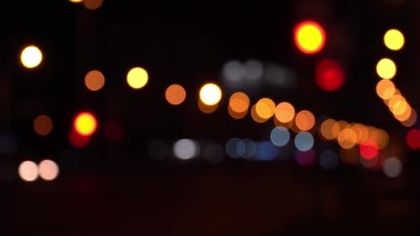 Runde bunte Bokeh leuchten von der Ampel im Stau auf der Stadtstraße. Wunderschönes glitzerndes Bokeh vor dunklem, verschwommenem Hintergrund in der Nacht. Abstraktes Konzept. Spiegelt einsamen Lebensstil in der Hauptstadt wider. - Filmmaterial, Video