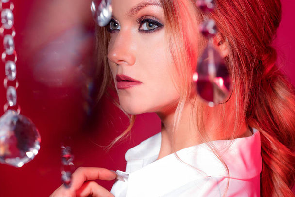 Portrait of gorgeous young blonde among sparkling crystals, pink tone and light. - Photo, image