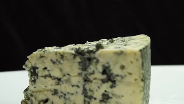Sinihomejuuston koostumus. Sininen jalo sinihomejuusto pyörii lautasella. Tuoksuva sininen juustot jalo hometta - Materiaali, video