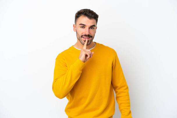 Young caucasian man isolated on white background showing a sign of silence gesture putting finger in mouth - Zdjęcie, obraz