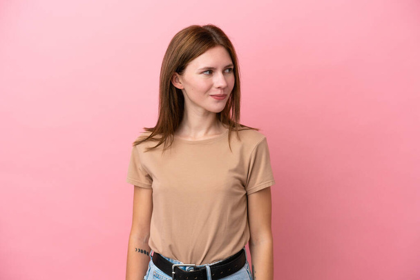 Young English woman isolated on pink background having doubts while looking side - Photo, Image