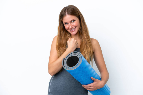 Young sport woman going to yoga classes while holding a mat celebrating a victory - Foto, imagen