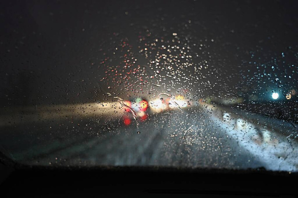 Peligrosa temporada de invierno con nieve en la carretera. El interior del coche desde el punto de vista del conductor - peligroso tráfico nocturno con mal tiempo. - Foto, imagen