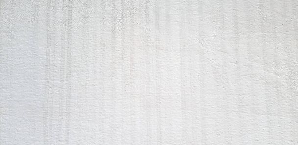Water or raining stains on white concrete wall. Dirty or messy cement wallpaper. Art and Abstract background. Close up surface of hard material. - Foto, afbeelding