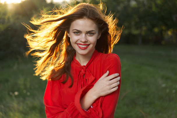 cheerful woman in a red dress in a field outdoors fresh air - Фото, зображення