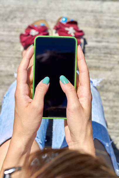 Female using modern smartphone outdoors. - Photo, Image