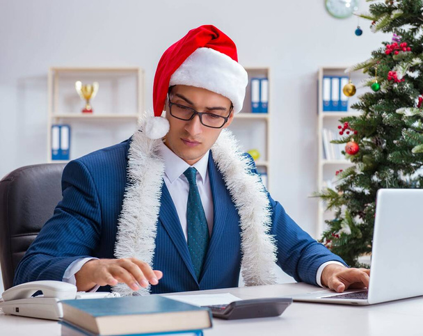 İş adamı Noel tatilini ofiste kutluyor. - Fotoğraf, Görsel