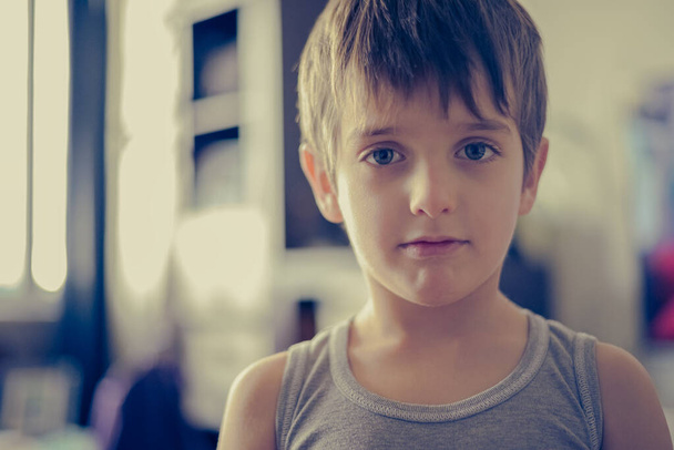 Portrait head shot of sad young boy child looking at camera - 写真・画像