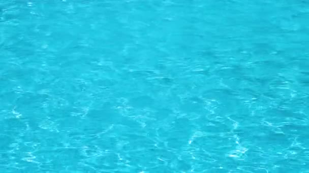 Superfície de close-up de água clara azul com pequenas ondas de ondulação na piscina - Filmagem, Vídeo