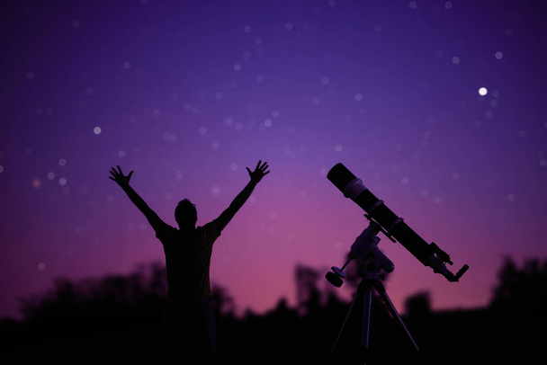 Silhouette of a man, telescope and countryside under the starry skies. - Photo, Image
