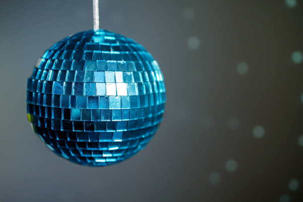 Large blue mirror ball with multi-colored reflections on a dark background. - Photo, Image